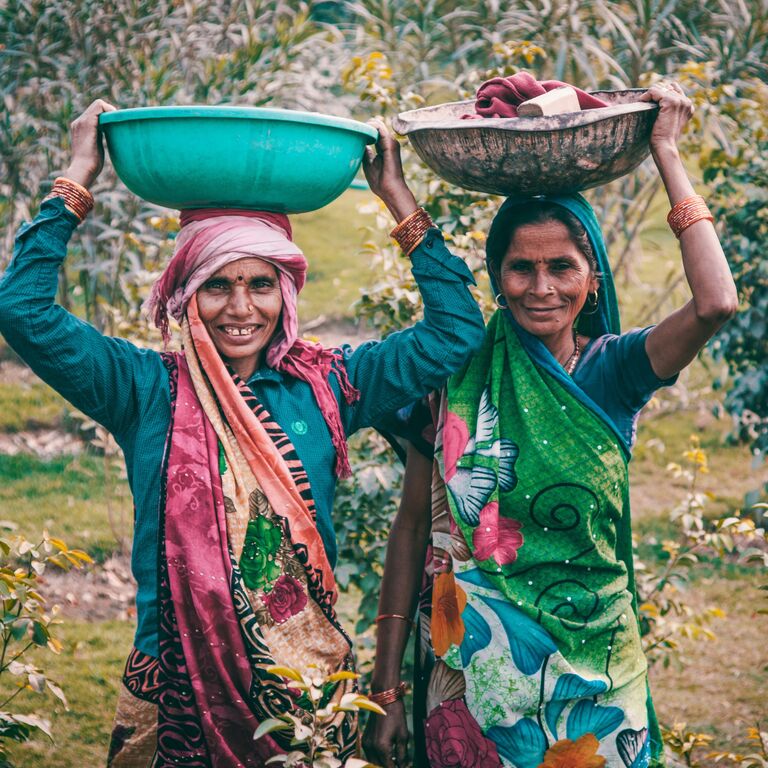 Two Indian women carrying baskets